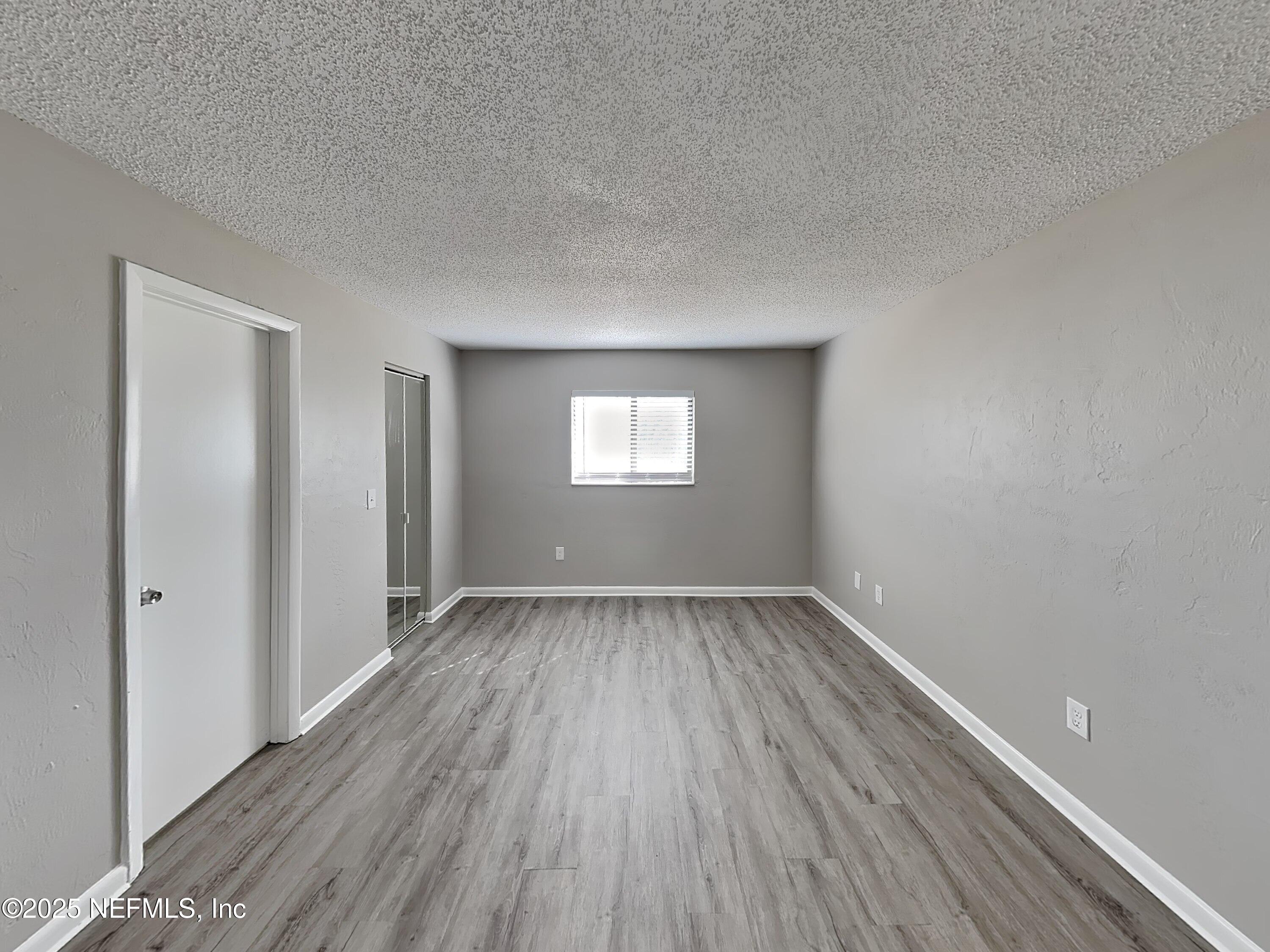 31 Folson Lane Palm Coast, FL 32137 - Photo 8 of 15 a view of an empty room with wooden floor and a window