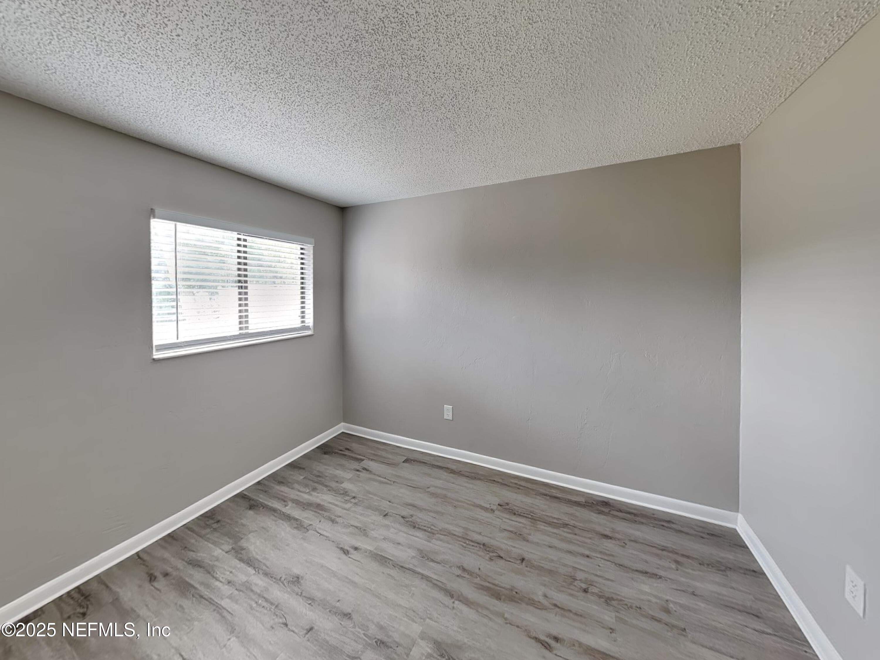 31 Folson Lane Palm Coast, FL 32137 - Photo 10 of 15 an empty room with wooden floor and windows