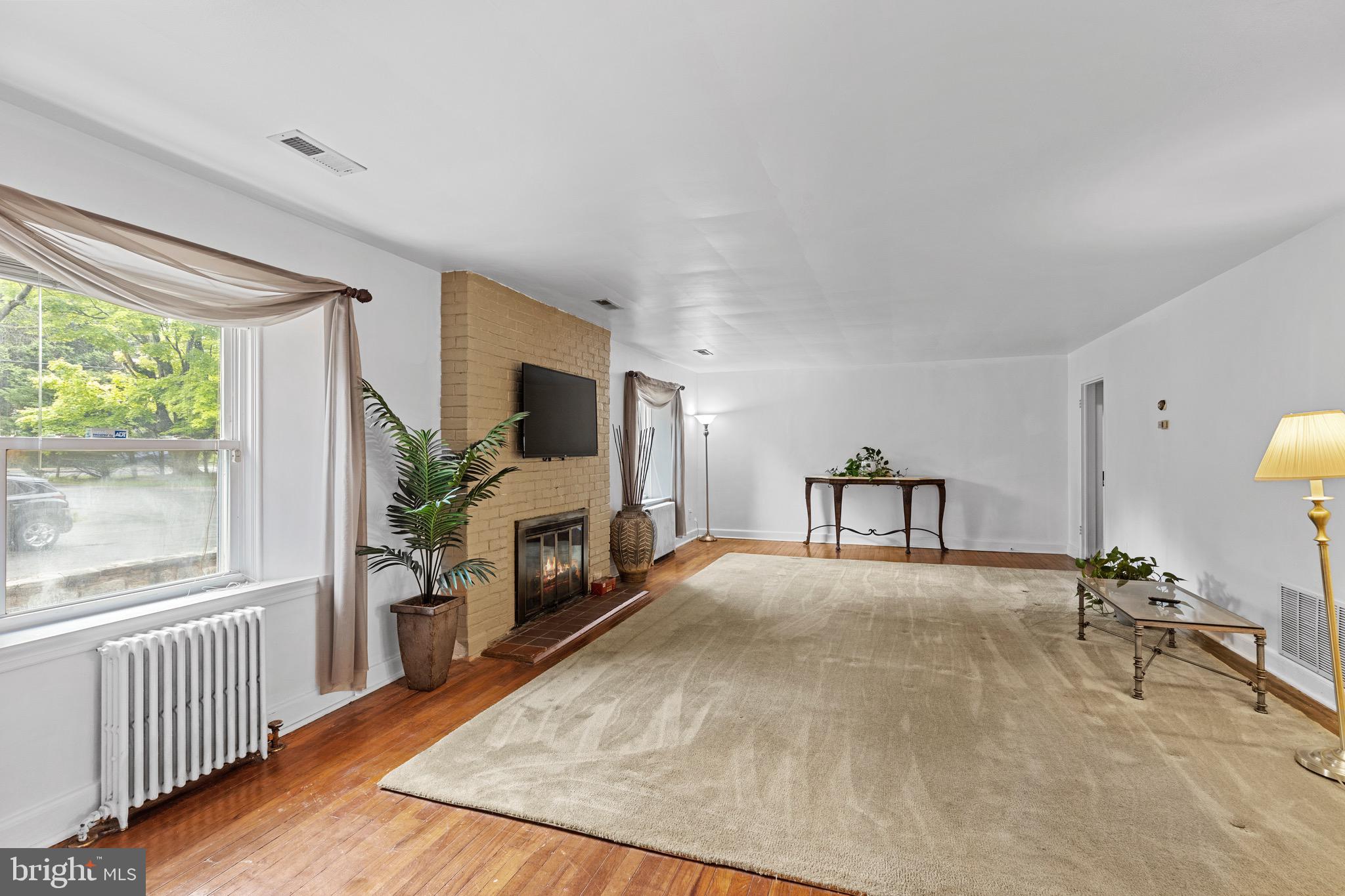 9214 Frederick Road Ellicott City, MD 21042 - Photo 4 of 41 bright natural light and a fireplace focal point