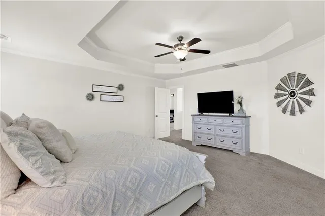 a spacious bedroom with a bed and a flat screen tv