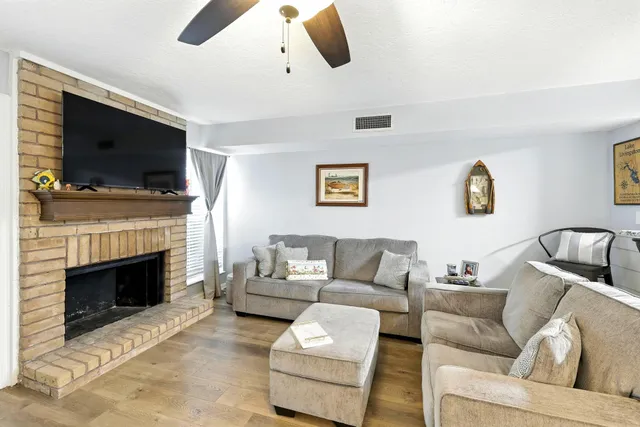 a living room with furniture a flat screen tv and a fireplace