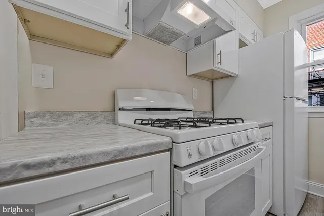 a stove top oven sitting inside of a kitchen