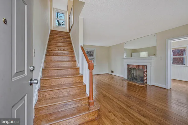 a view of an entryway with wooden floor and fireplace