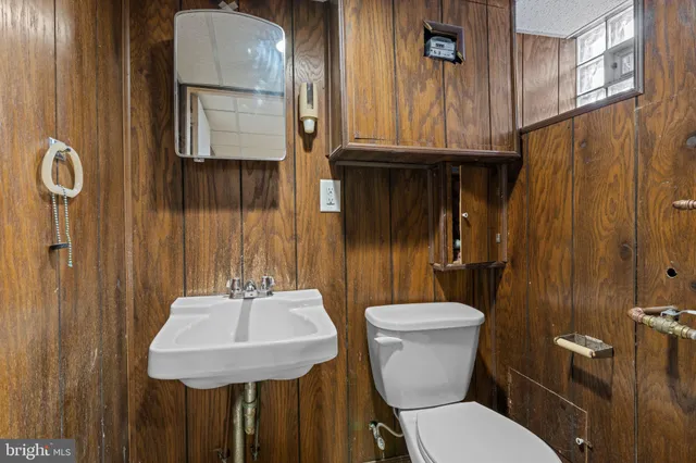 a bathroom with a toilet a sink and mirror