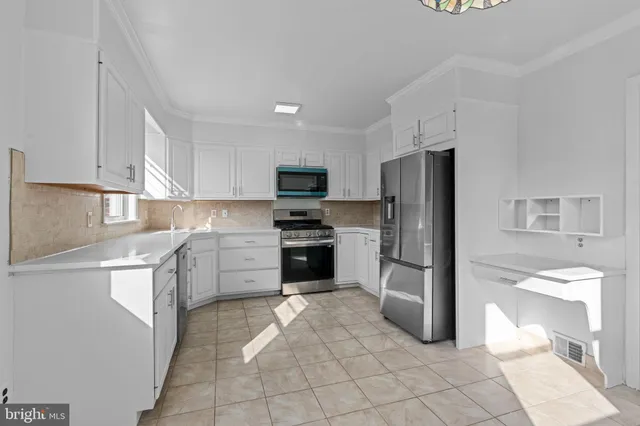 a kitchen with a refrigerator sink and cabinets