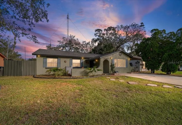 a front view of house with yard and trees in the background