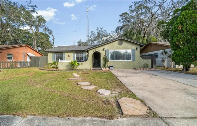 a front view of a house with a yard and trees