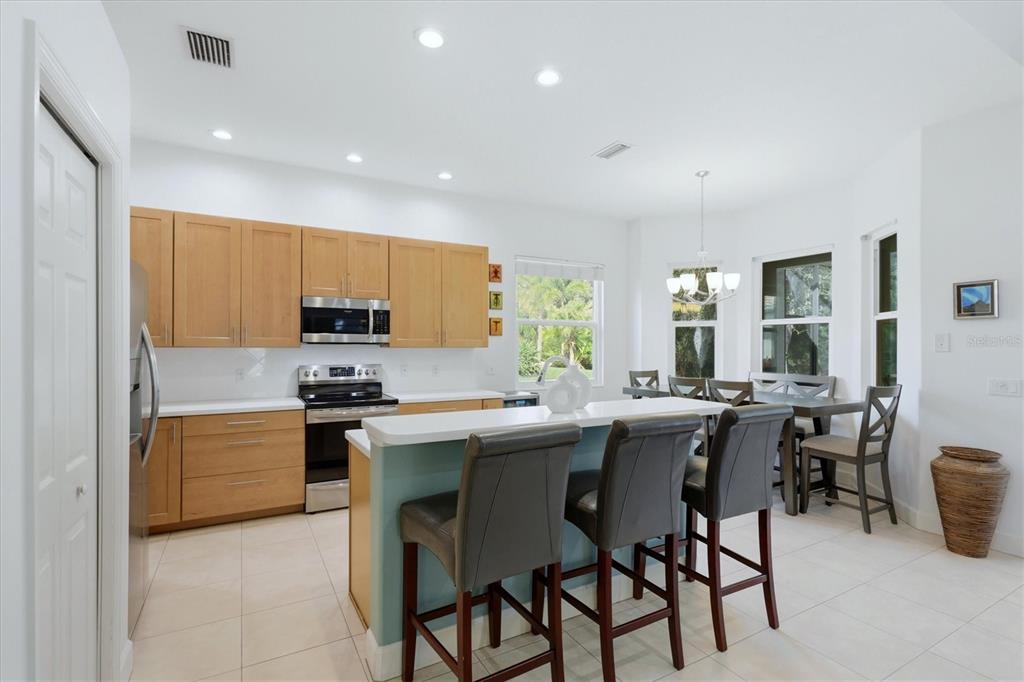 745 Fordingbridge Way Osprey, FL 34229 - Photo 15 of 53 a kitchen with stainless steel appliances a table and chairs in it