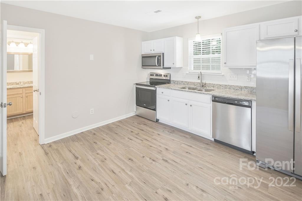 236 Pangle Drive Charlotte, NC 28217 - Photo 11 of 26 a kitchen with granite countertop white cabinets and white appliances