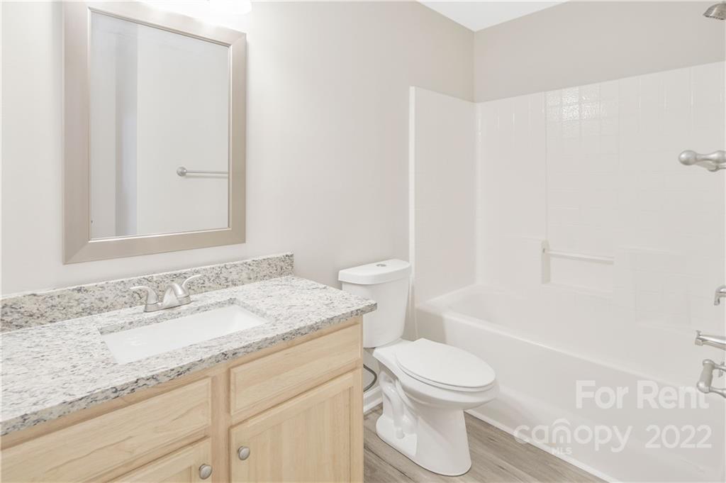 236 Pangle Drive Charlotte, NC 28217 - Photo 18 of 26 a bathroom with a granite countertop sink toilet a mirror and shower