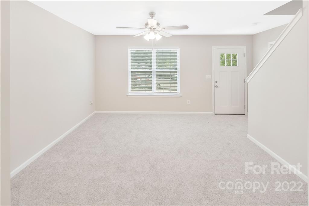 236 Pangle Drive Charlotte, NC 28217 - Photo 8 of 26 an empty room with windows and chandelier fan