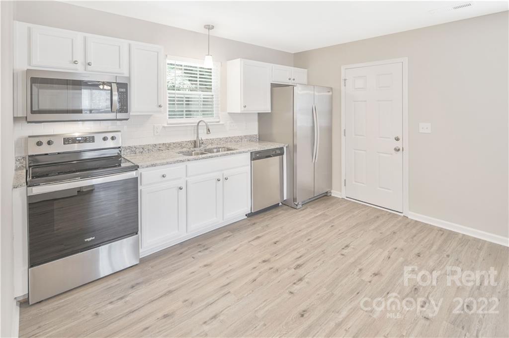 236 Pangle Drive Charlotte, NC 28217 - Photo 9 of 26 a kitchen with granite countertop white cabinets and stainless steel appliances