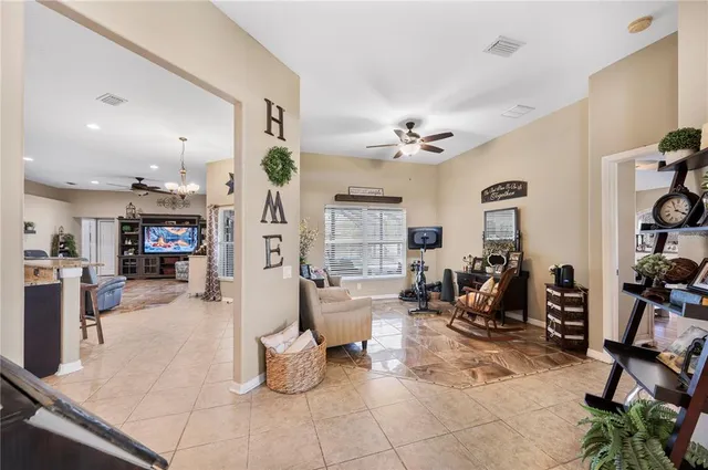 a large kitchen with stainless steel appliances granite countertop a refrigerator a sink dishwasher a stove and a dining table with wooden floor