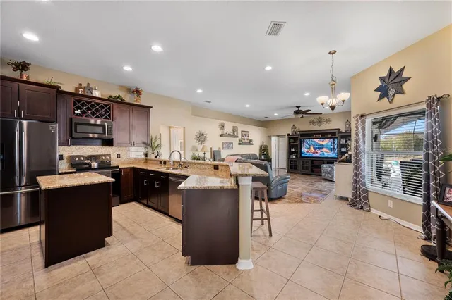 a kitchen with stainless steel appliances kitchen island granite countertop a refrigerator stove and oven