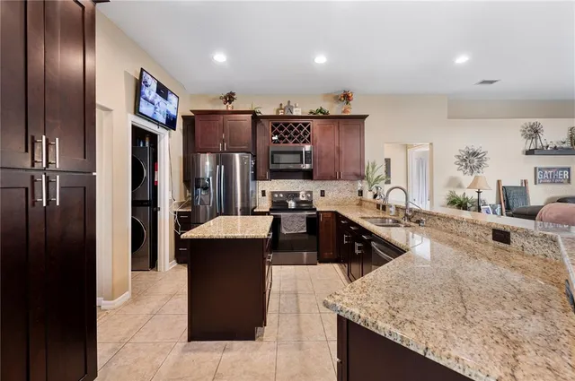 a kitchen with stainless steel appliances kitchen island granite countertop a refrigerator and a stove top oven