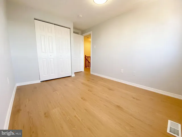 an empty room with a wooden floor and a window