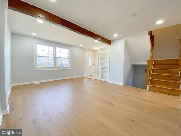 a view of empty room with wooden floor and window