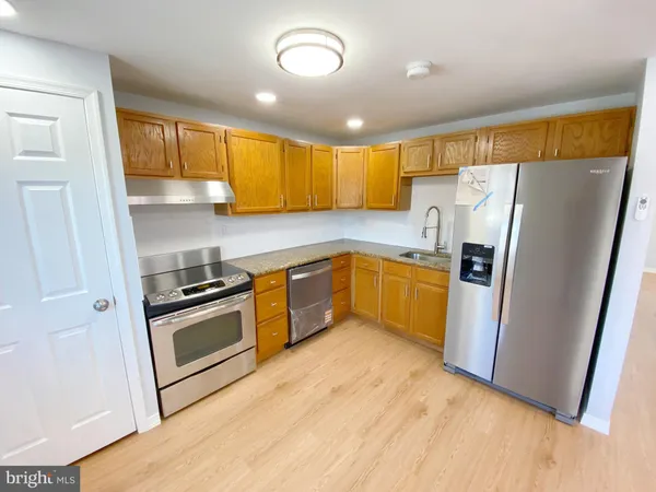 a kitchen with a refrigerator sink and wooden floor
