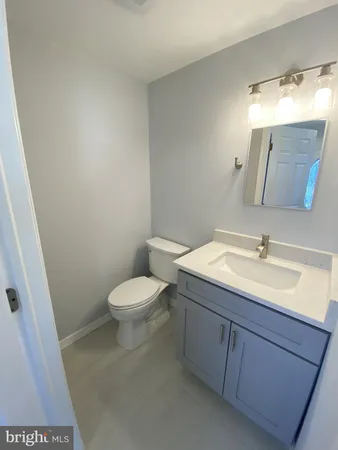 a bathroom with a toilet a sink a mirror and vanity
