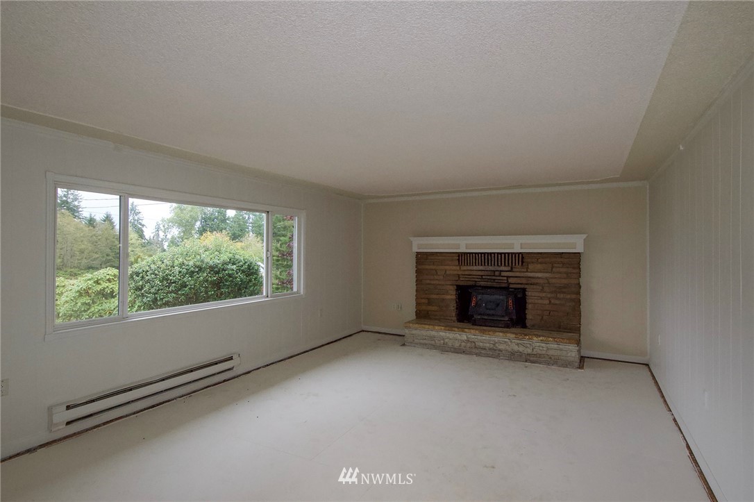 190 Roupe Road Sequim, WA 98382 - Photo 4 of 20 an empty room with fireplace and windows
