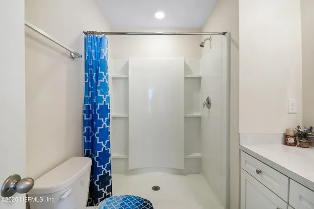 a bathroom with a shower a toilet and a sink