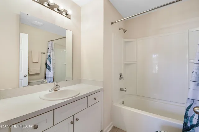 a bathroom with a sink double vanity granite tub shower and a mirror