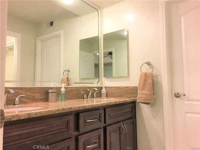 a bathroom with double vanity and two mirror
