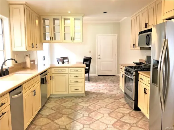 a kitchen with stainless steel appliances a stove a sink a refrigerator and cabinets