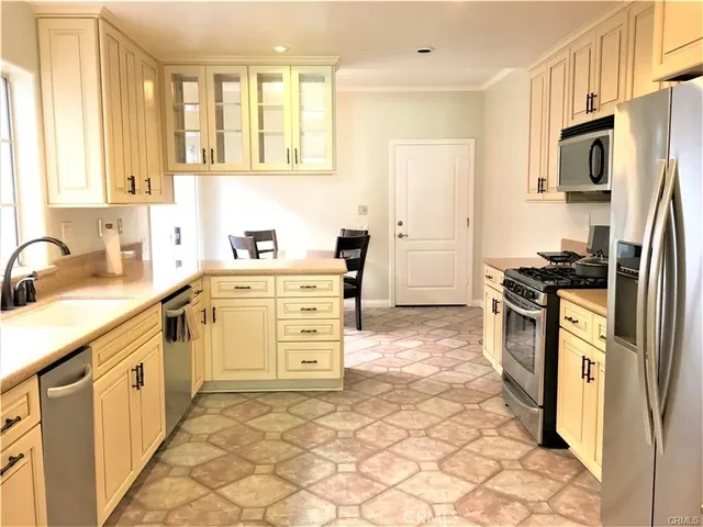 a kitchen with stainless steel appliances a stove a sink a refrigerator and cabinets