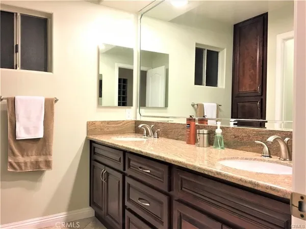 a bathroom with a granite countertop sink and a mirror