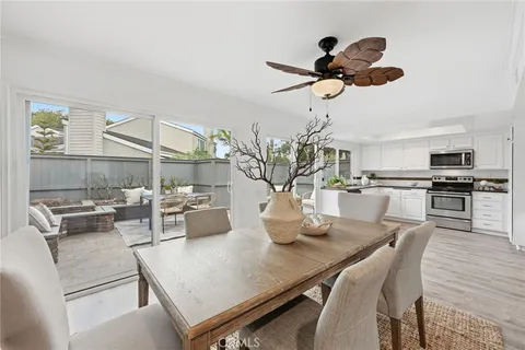 a dining room with wooden floor a chandelier a wooden table and chairs