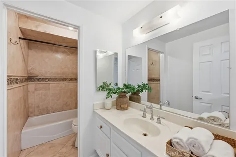 a bathroom with a granite countertop sink and a bathtub