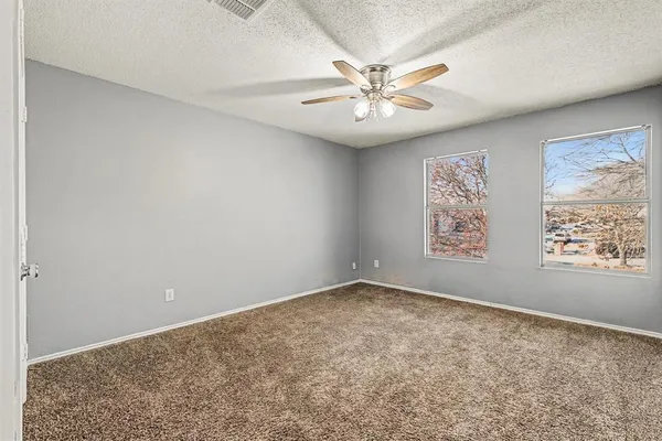 a view of a big room with window and chandelier fan