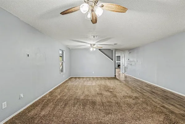an empty room with chandelier fan