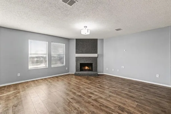 a view of an empty room with a window and fireplace