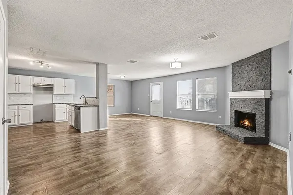 a view of an empty room with a fireplace and window