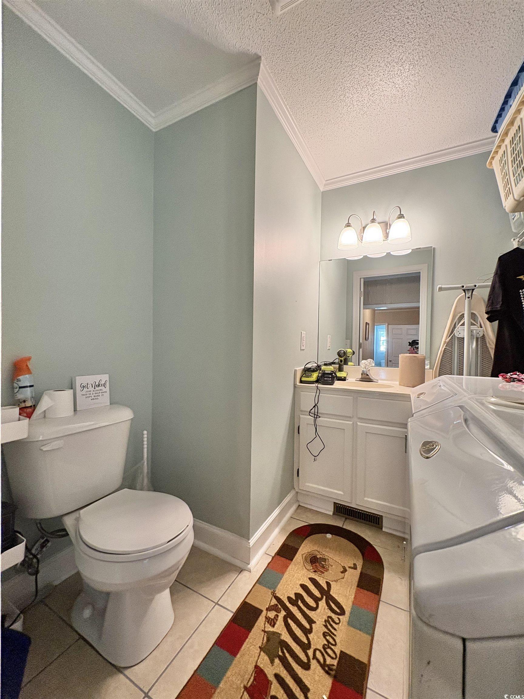 520-526 Boundary Avenue Murrells Inlet, SC 29576 - Photo 13 of 38 Bathroom featuring light tile patterned floors, a textured ceiling, vanity, and ornamental molding
