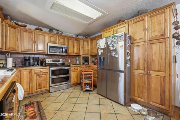 a kitchen with stainless steel appliances granite countertop a refrigerator stove microwave and sink