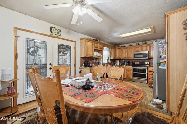 a living room with furniture a large window and stainless steel appliances
