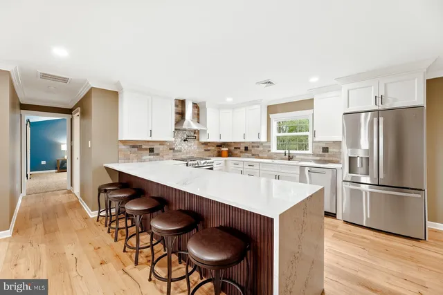 a kitchen with stainless steel appliances kitchen island a table and chairs in it