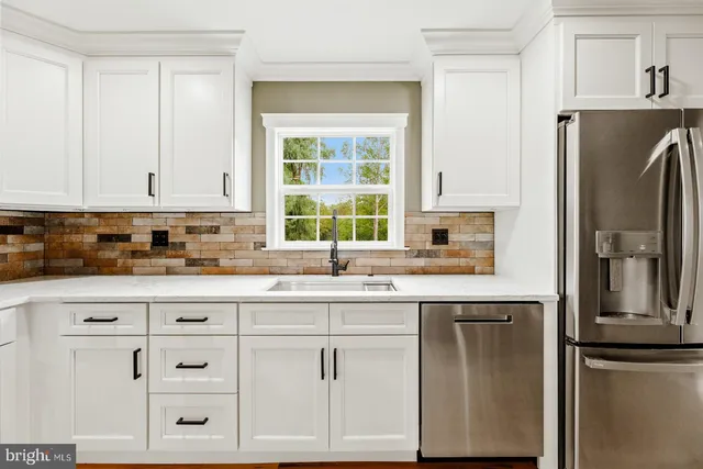 a kitchen with cabinets appliances and a window
