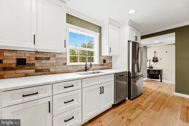 a kitchen with stainless steel appliances a sink stove and refrigerator