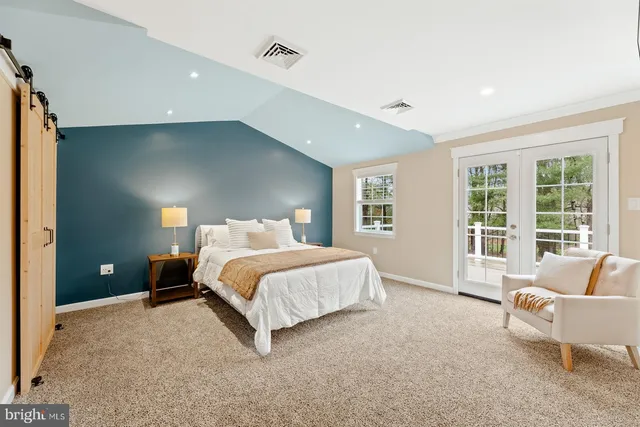 a spacious bedroom with a bed and glass window