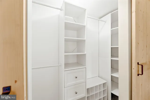 a view of walk in closet with empty racks