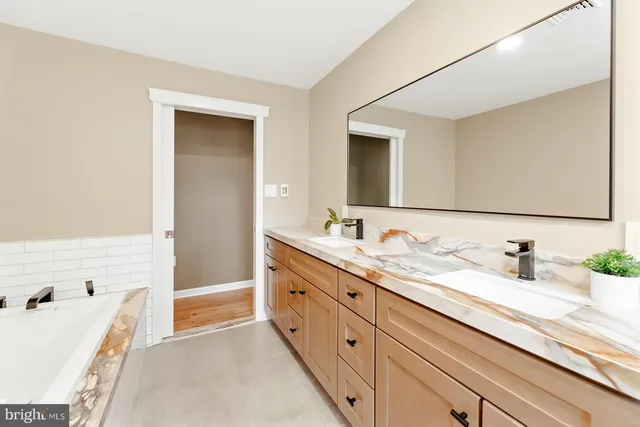 a bathroom with a double vanity sink and a bathtub