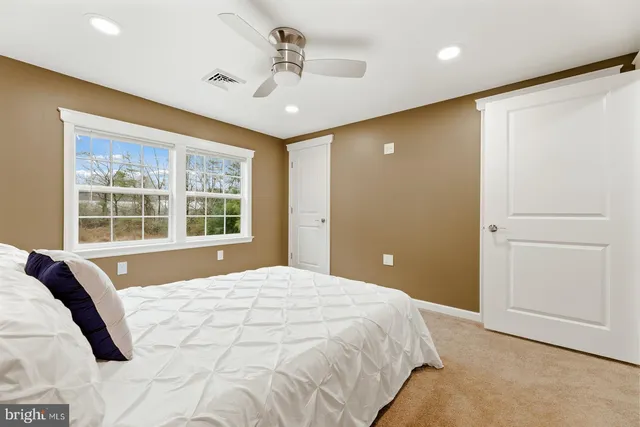 a spacious bedroom with a large bed and a chandelier