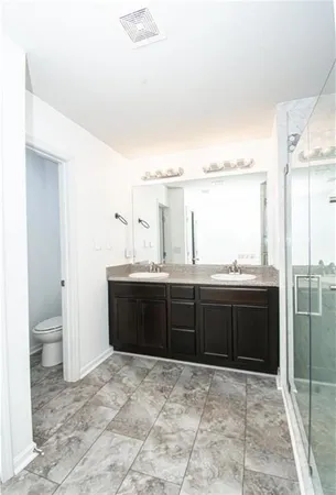 a bathroom with a granite countertop sink a toilet and a vanity