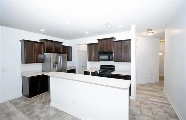a kitchen with stainless steel appliances a refrigerator sink and microwave
