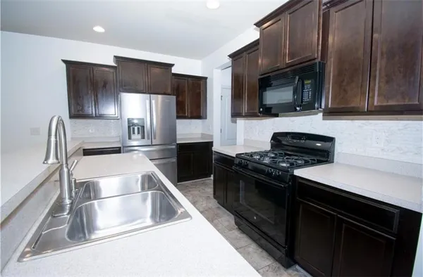 a kitchen with stainless steel appliances granite countertop a sink and a stove top oven