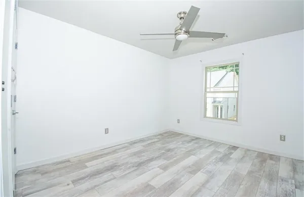 an empty room with a window and a ceiling fan